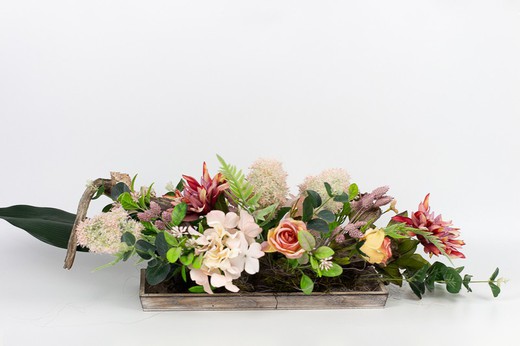 Centre de table allongé avec des fleurs de rose, de renoncule et d'hortensia.