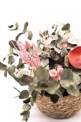 Cesta de mimbre decorada con flores secas y preservadas en tonos