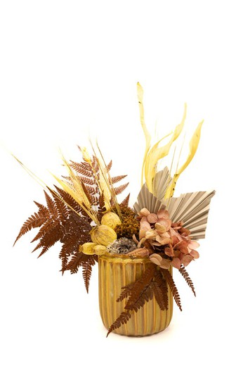 Vase en céramique avec fleurs stabilisées et fleurs séchées dans les tons moutarde et jaune