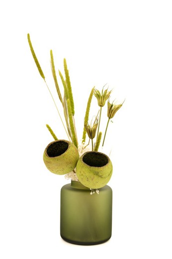 Pequeno vaso de vidro verde opaco com flores secas e flores em conserva