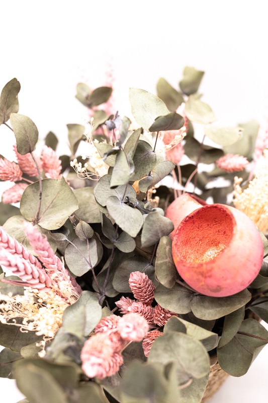 Cesta de mimbre decorada con flores secas y preservadas en tonos